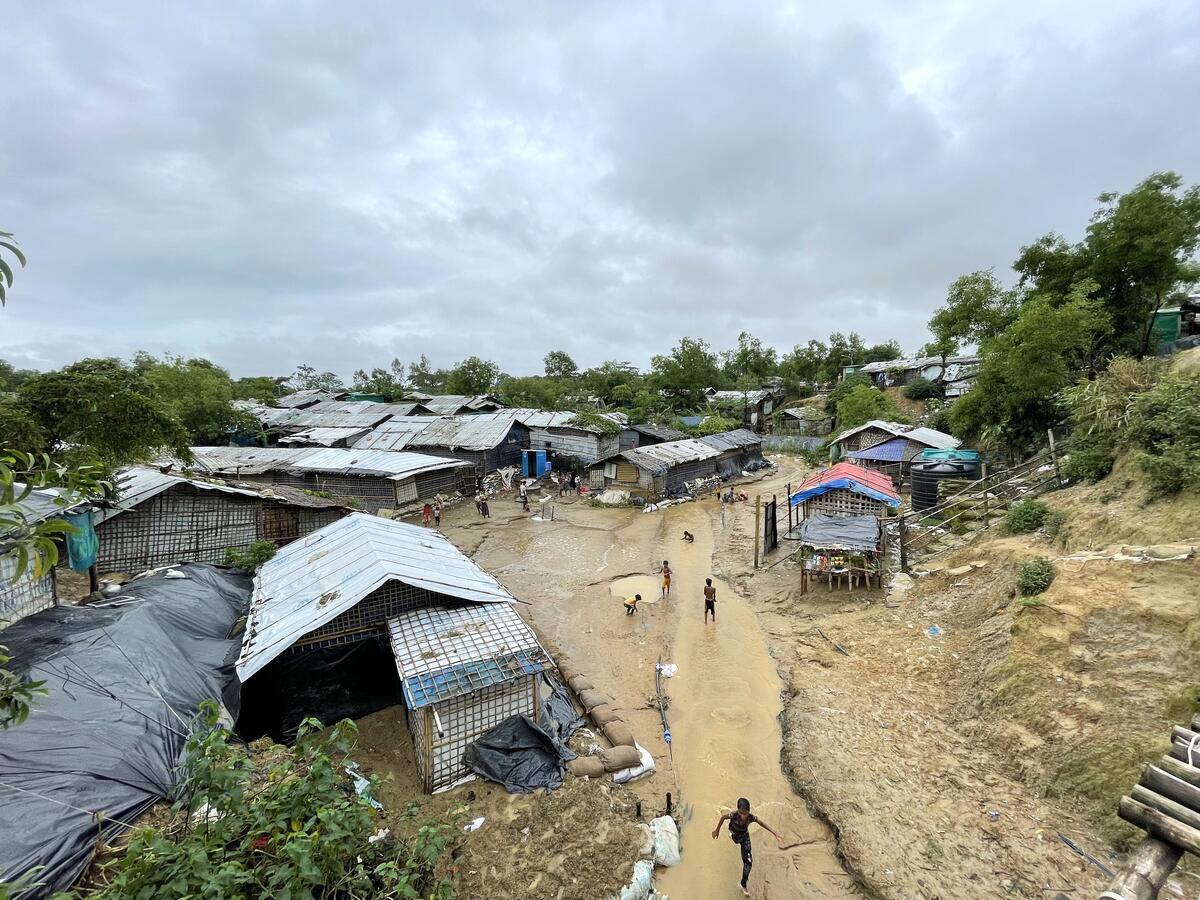 Children play in water following monsoon rains at a refugee camp.
