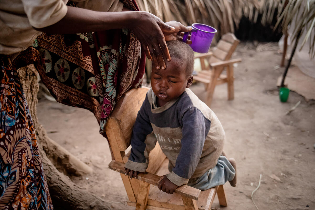 Democratic Republic of the Congo. A refugee cleans her kid's face
