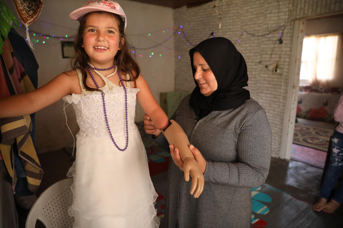 Safiyah le ayuda a Sarah a ponerse el brazo protésico, el cual fue proporcionado por Bionic Family, una ONG libanesa.