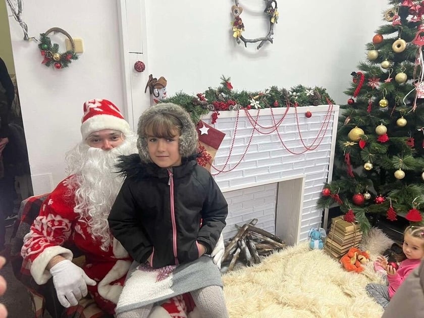 La refugiada ucraniana Sofía conoce a Santa Claus durante un bazar de beneficencia navideño en el hospital.