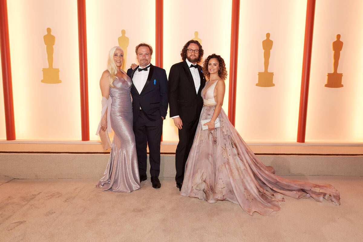 United States. Oscar nominees Frank Petzold, Markus Frank and guests arrive on the red carpet of the 95th Oscars and wear blue ribbons in solidarity with refugees