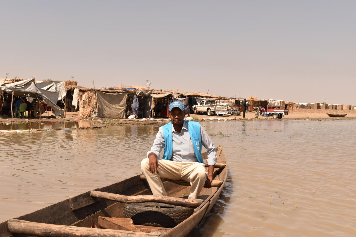 Sudan. A UNHCR staff member uses a boat to access refugees cut off by the floods.