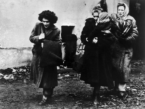 Black and white photo of three women and a child arriving at a refugee camp in Austria.
