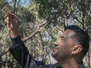 A man looks at an ID he is holding up.