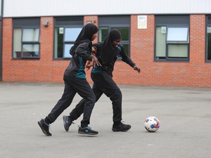 two girls play football