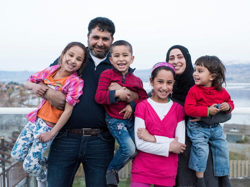 Canada. Mohammad, a Syrian refugee, poses on the balcony of the house his sponsors have rented for him and his family. Also in the photo are his wife Sahar and their four children