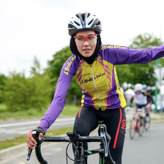 Masomah waving from her bike during a race.