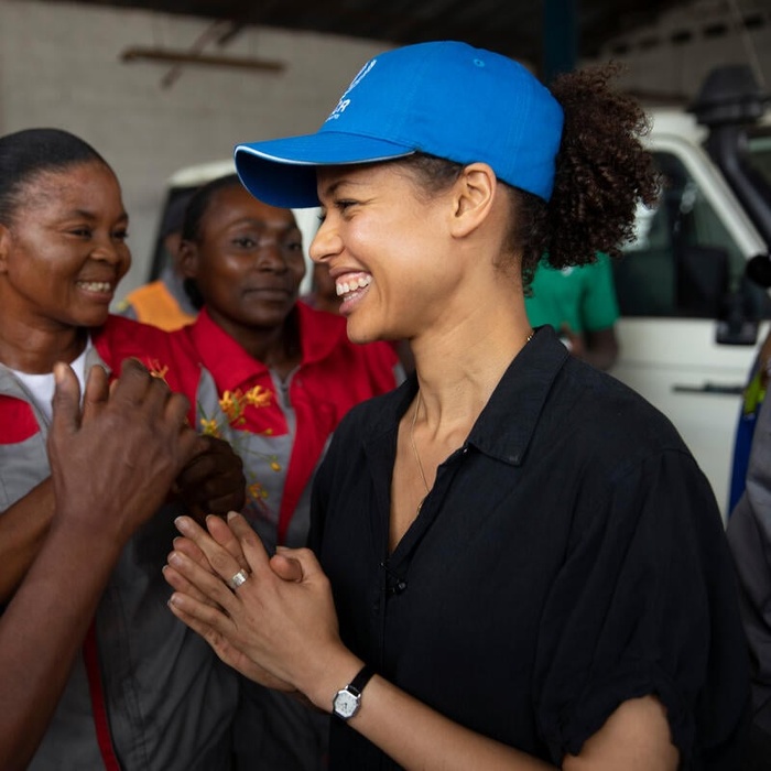 Gugu Mbatha-Raw laughs with refugee women.