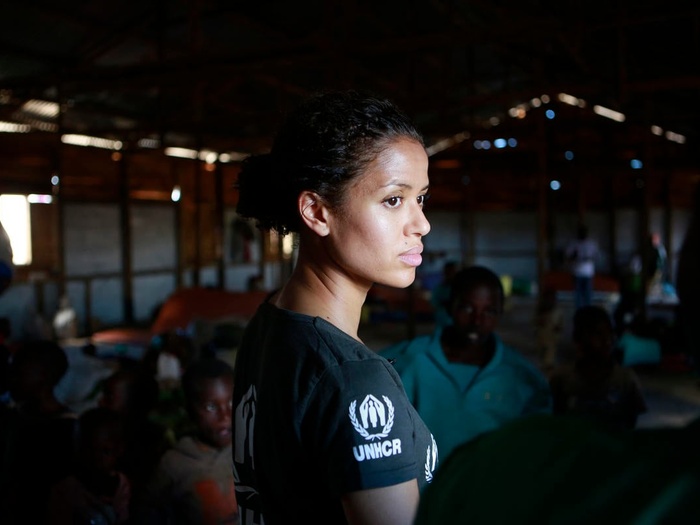  Gugu Mbatha-Raw stands in a room, wearing a UNHCR black t-shirt.