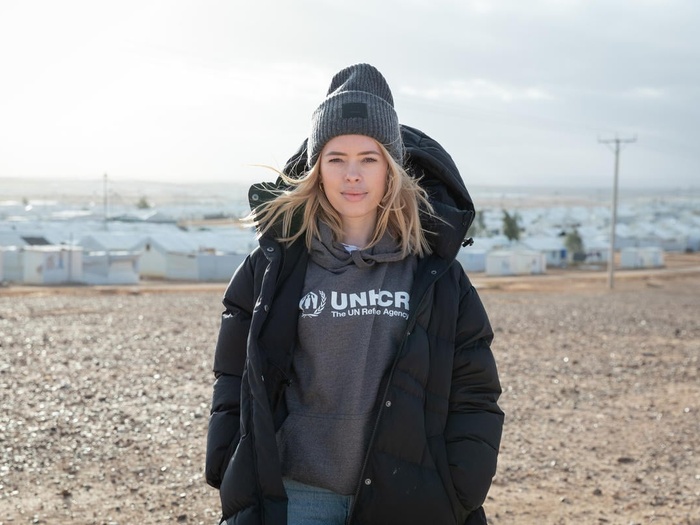 Tanya Burr standing on a high point overlooking a refugee camp.