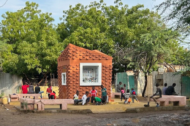 A brick pavillion with people sat nearby 