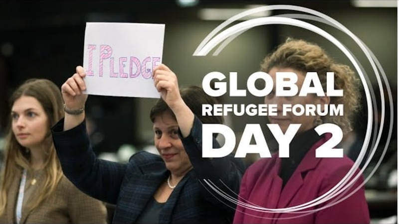 A woman holds a sign reading "I pledge".
