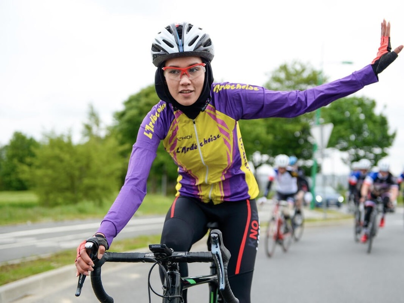 Masomah waving from her bike during a race.