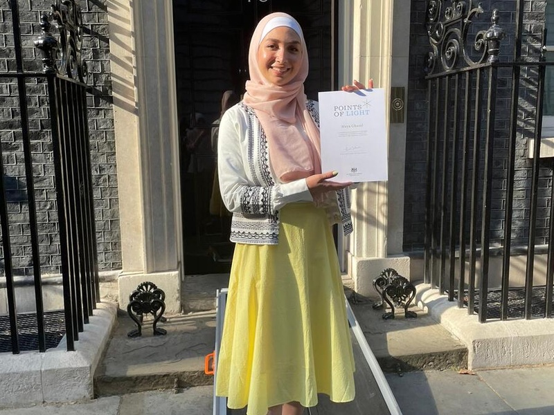 Maya Ghazal holding her "Point of Light" Award