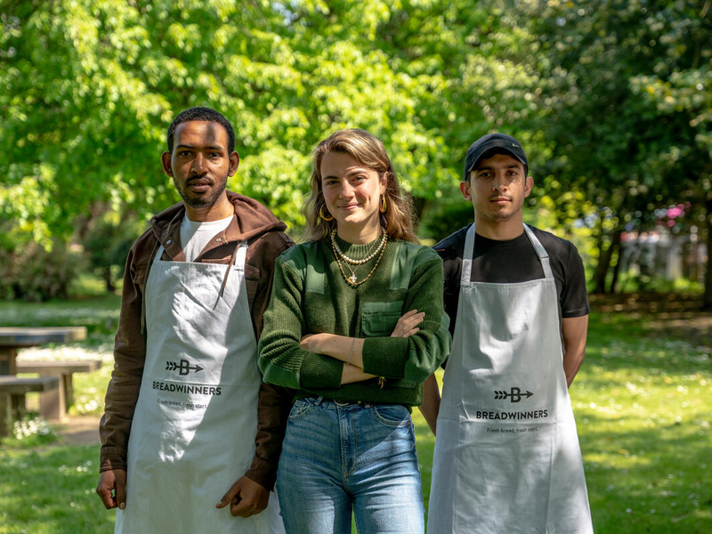 Two men and a woman pose in the park.