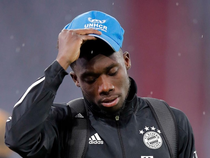 Alphonso Davies wears the UNHCR blue cap before a soccer game.