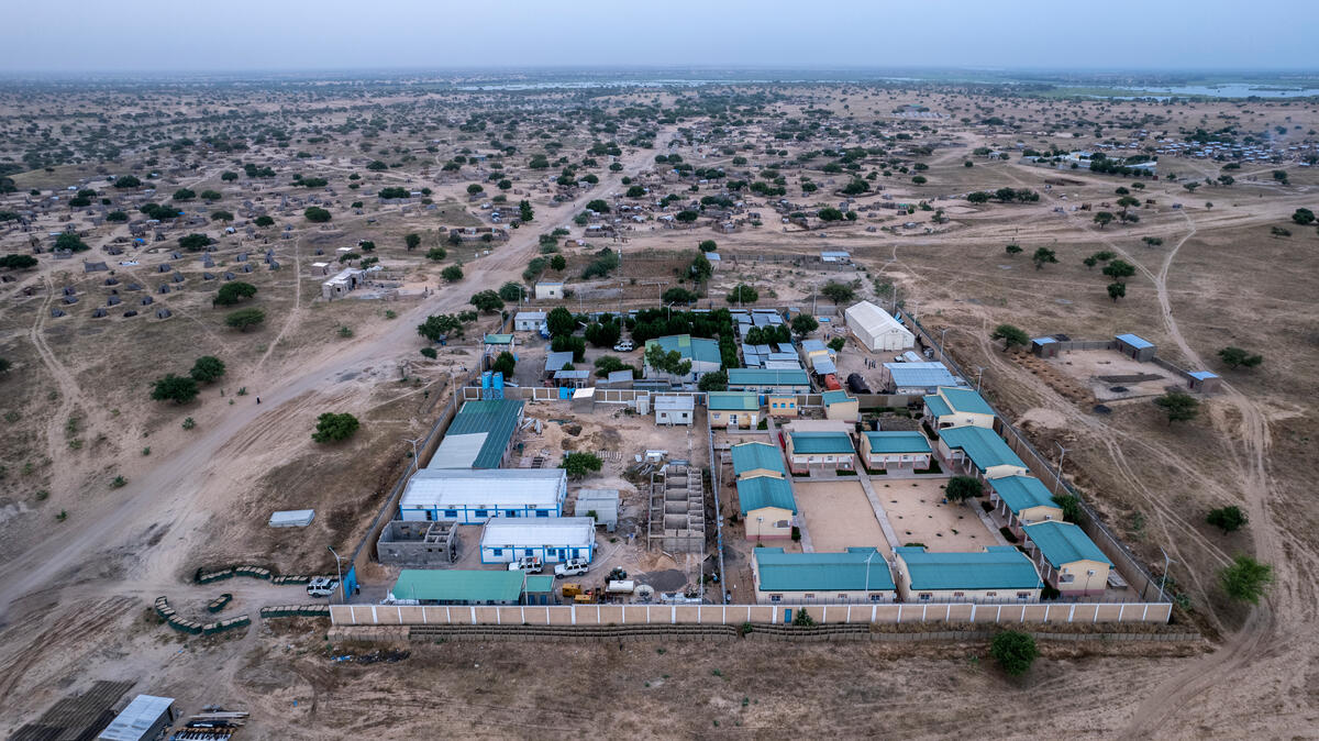 Aerial view of a small settlement in a very flat area with sparse trees.