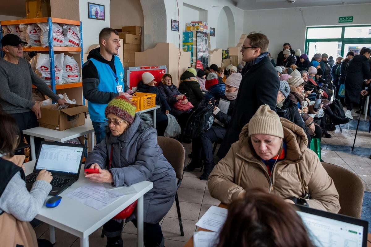 Ukrainian refugees sit inside an aid distribution centre in Poland.