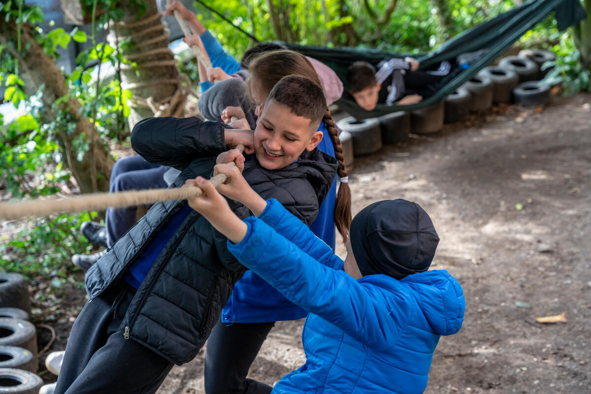 A boy plays on a rope swing.