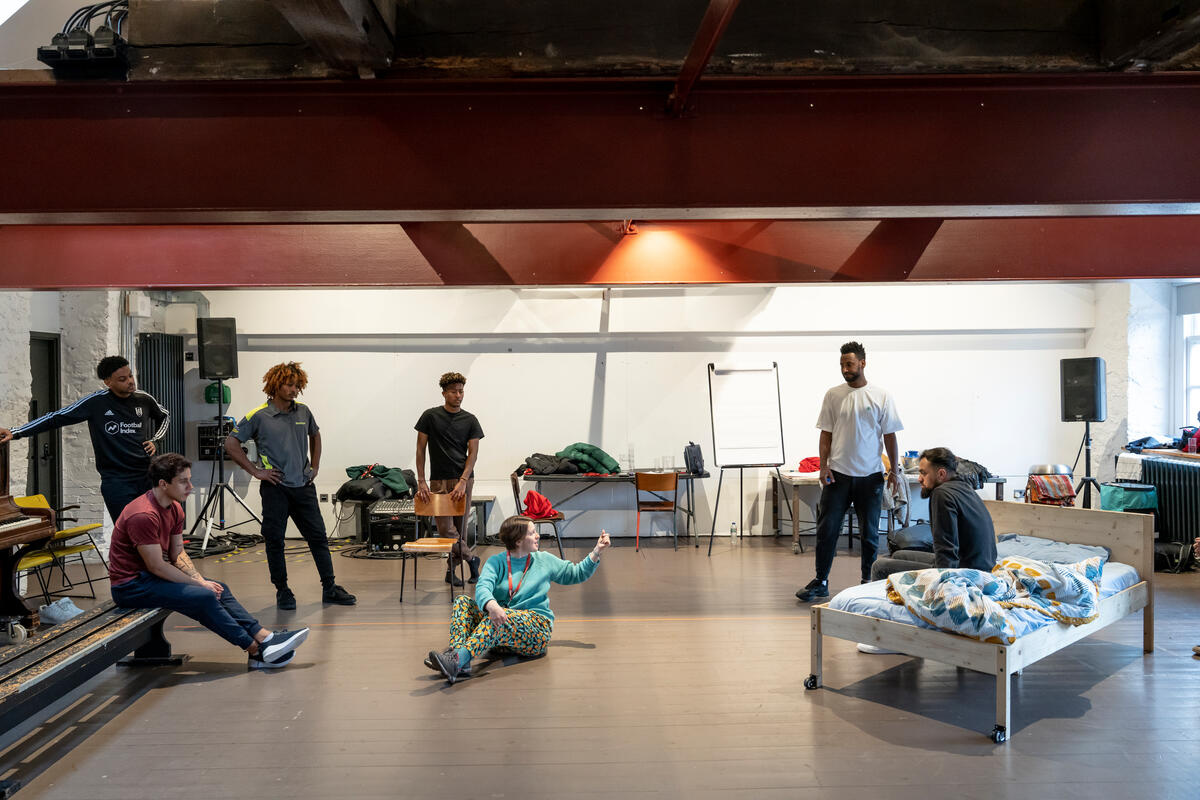 Six men and one woman in a rehearsal space.