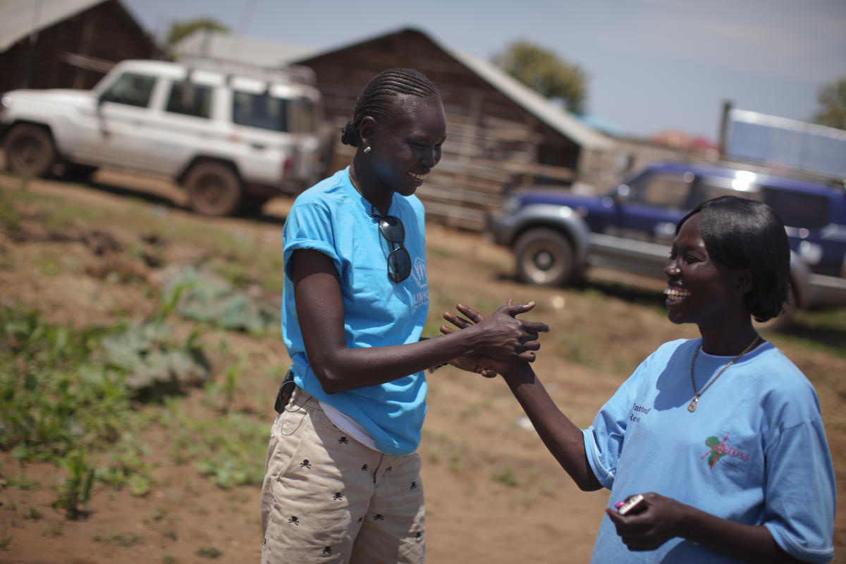 Alek Wek shakes hands with another woman.