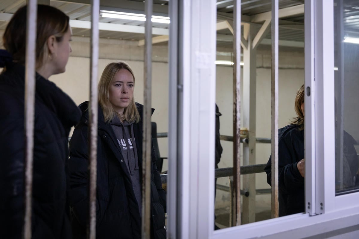 Tanya Burr looks through a window.