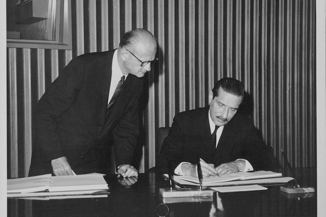 Black and white photograph of a man signing the final act of the Convention on the Reduction of Statelessness.