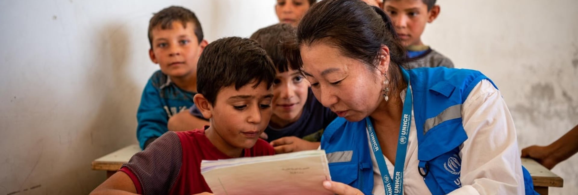 A UNHCR staff member reads a book with a child, in Aleppo, Syria.