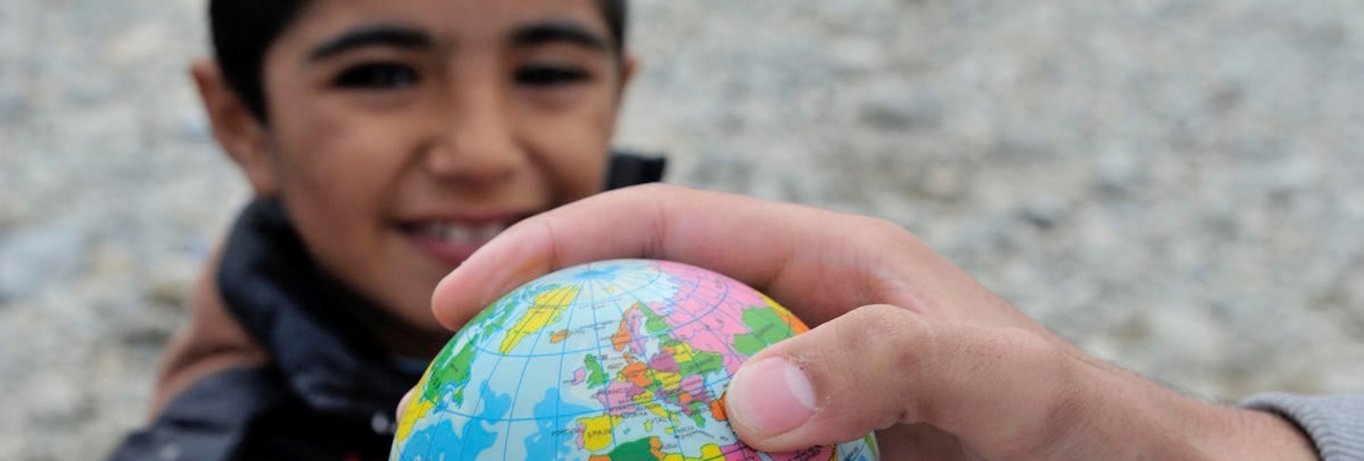 A young boy from Syria with a toy world globe, at the Vinojug Reception Centre just inside the Macedonian border from Greece.
