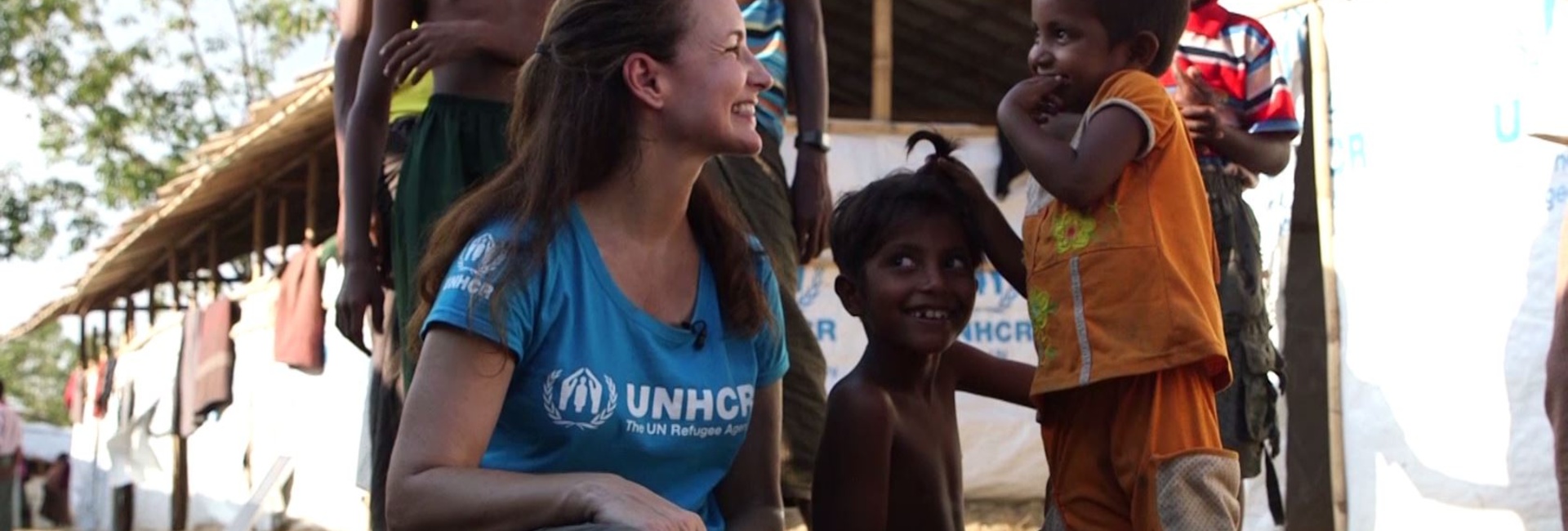 Kristin Davis smiling with several Rohingya refugee children