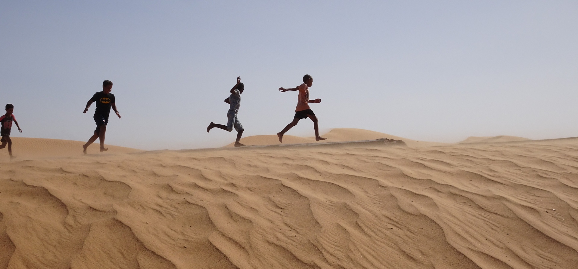 Young children from the Sahrawi community play on the sand dunes at Dakhla camp in Tindouf, western Algeria, close to the border with Morocco and Western Sahara.