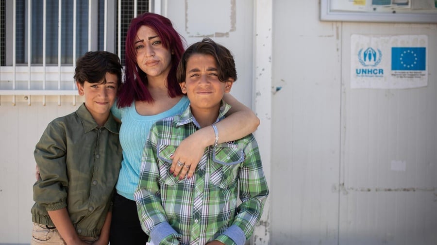 A woman and her two young sons, who are asylum-seekers from Syria, pose for a picture.