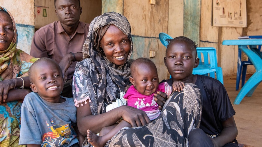 Sudanese refugee Intisar, 27, poses for a photograph with her three children