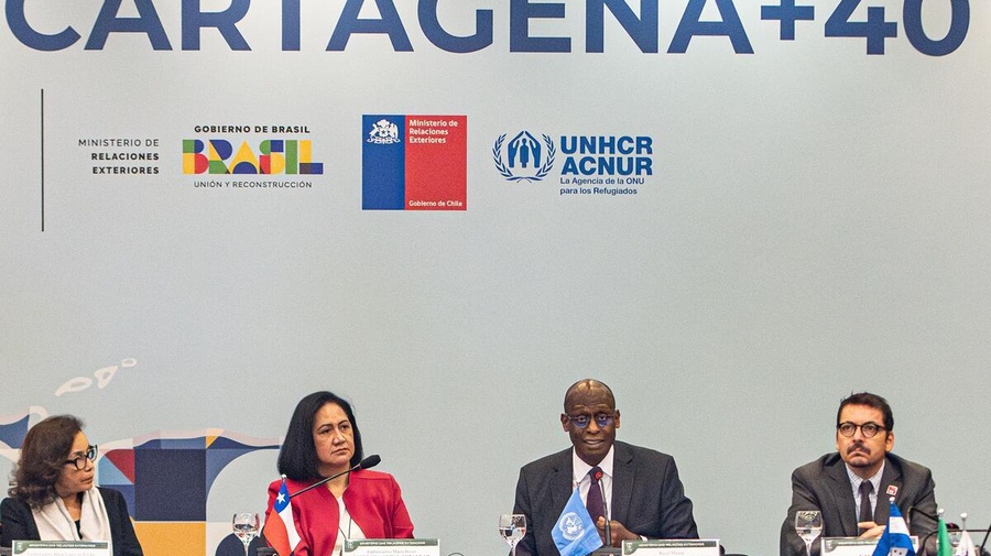Four people sit at a table with microphones at a consultation meeting, with 'Cartagena+40' and various logos on the wall behind them.