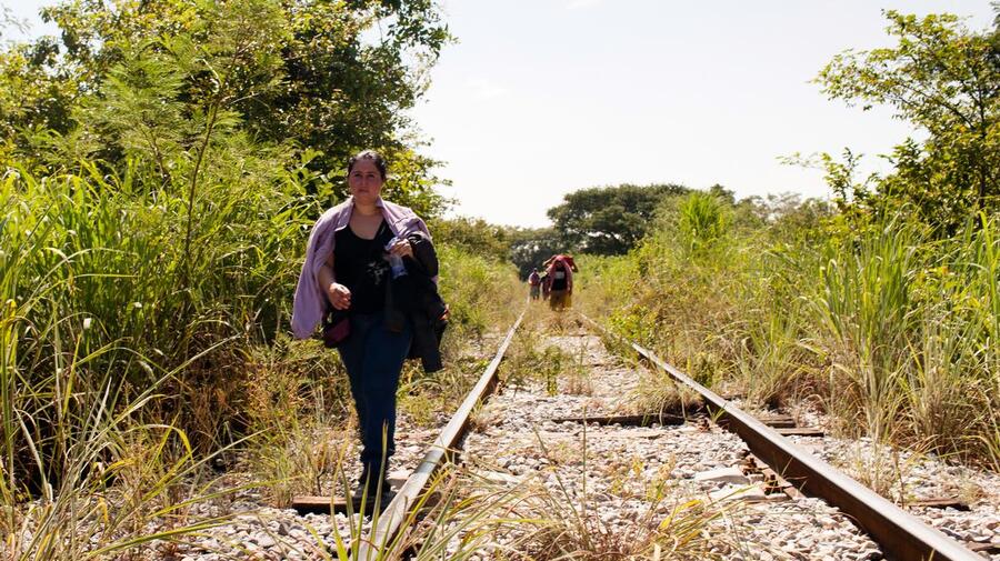 A woman fleeing El Salvador walks along the train tracks in Chiapas, Mexico.