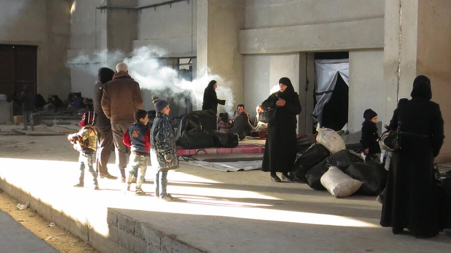 Newly displaced families from east Aleppo reach a shelter in Mahalej, Syria.