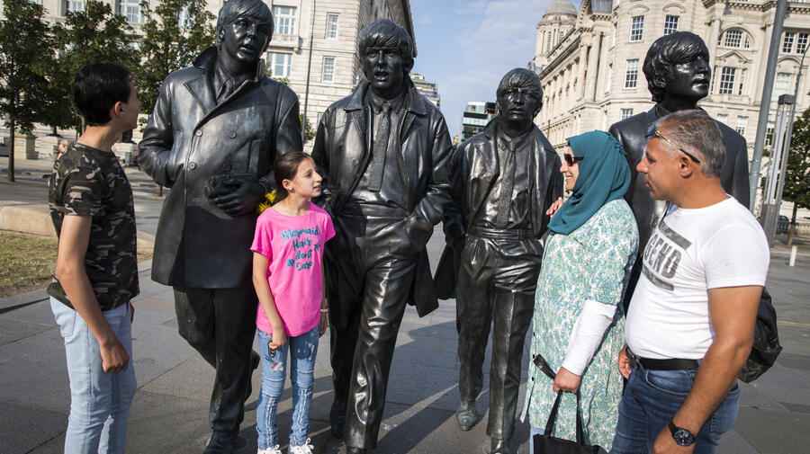 The Khaled Jhayem family (left to right) Adel, Ola, Ghofran and Ismael, stand near The Beatles statue on the waterfront in their new home, Liverpool. Ghofran had feared moving the children to a new country, and culture, but after six months she says they are happy.