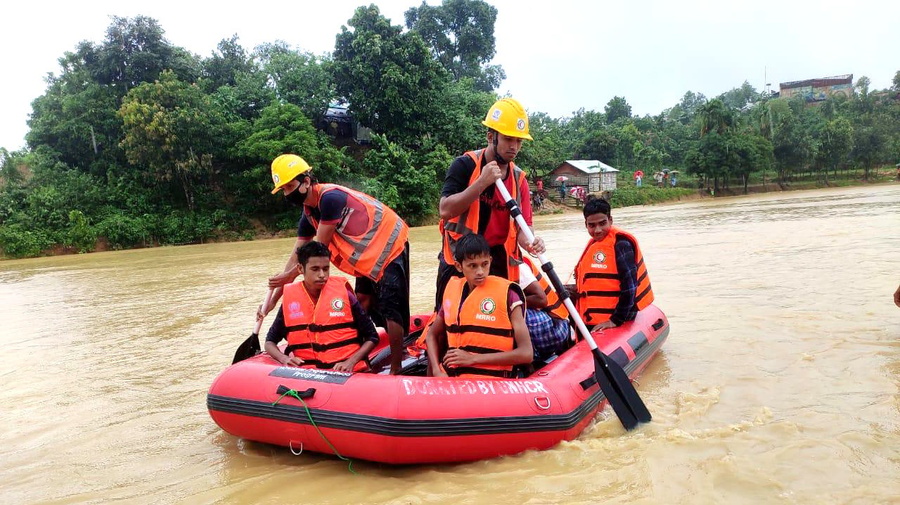 Rohingya refugees are paddled to safety at a site in Bangladesh's Cox's Bazar, after heavy monsoon rains  triggered flash floods and landslides.