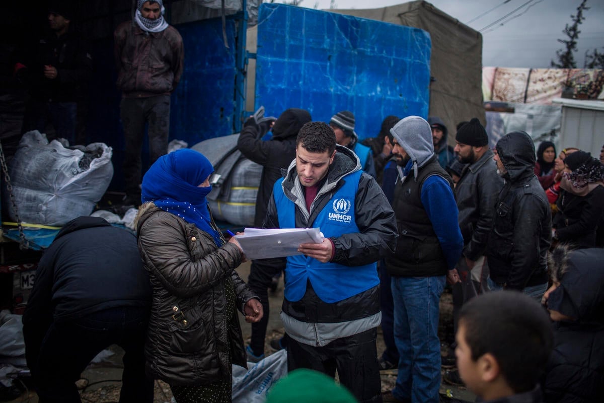 A UNHCR staff member speaks with a Syrian refugee woman in Lebanon