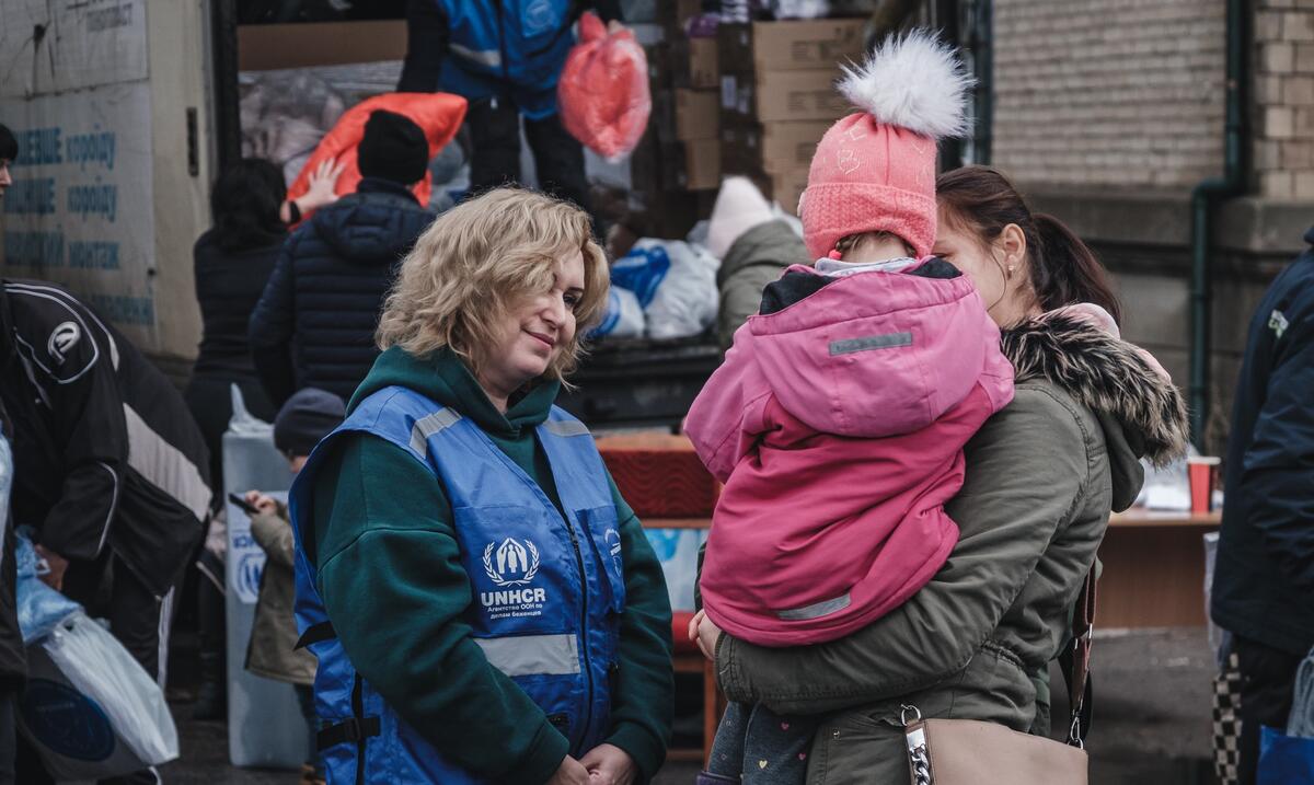 Anzhela (24) holds her little niece Liliya (4) as they wait to receive warm clothes and blankets.