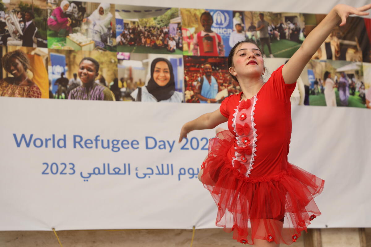 Ballet dancer dressed in red dances on stage.