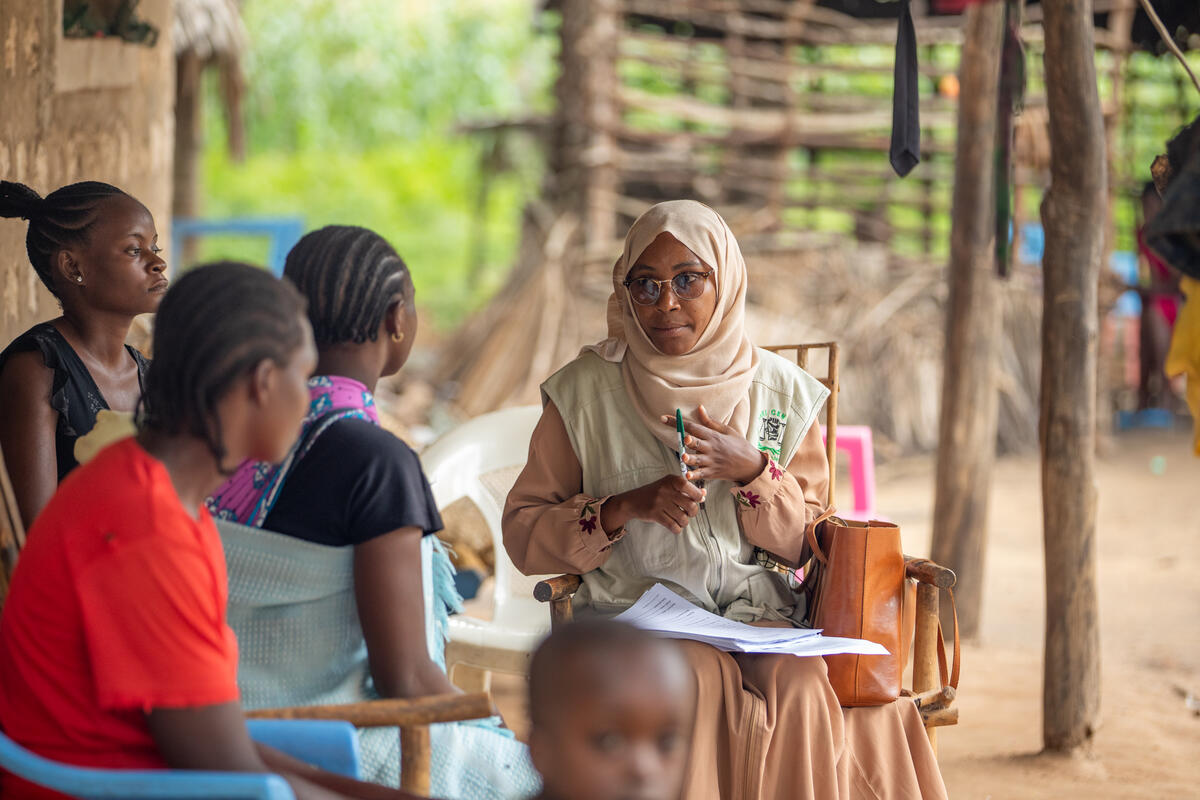 A group of women sit on chairs and discuss.
