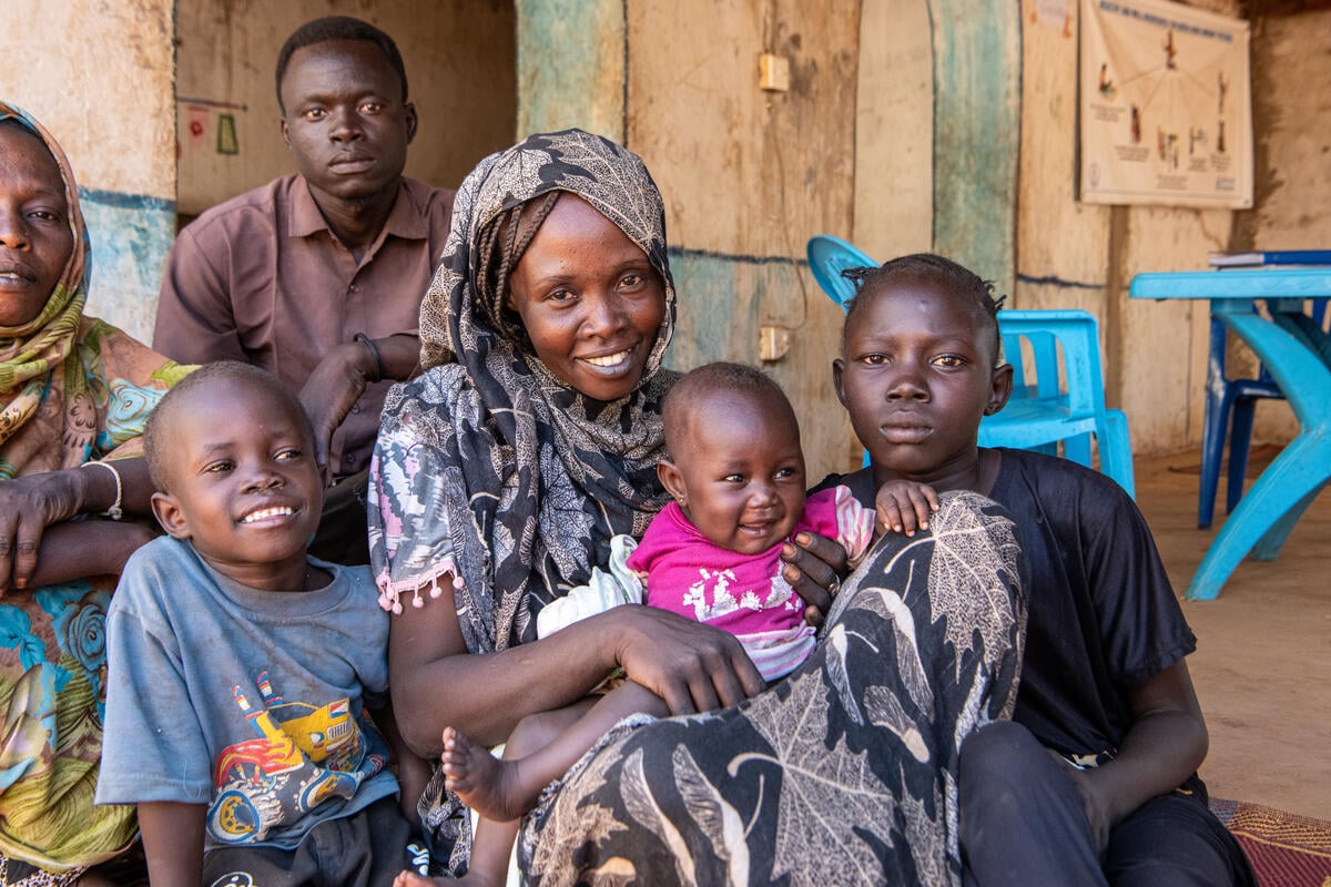 Sudanese refugee Intisar, 27, poses for a photograph with her three children