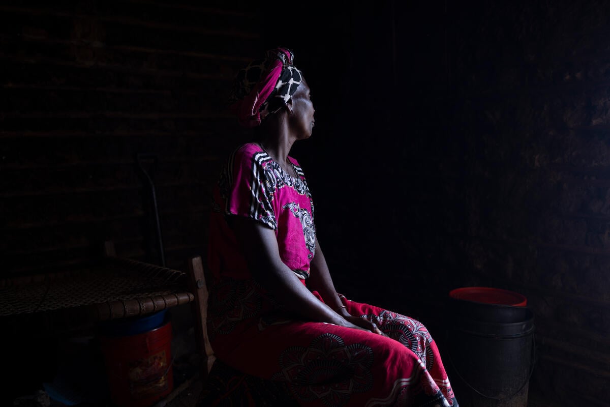 Portrait of a woman with her face turned away against a dark background.
