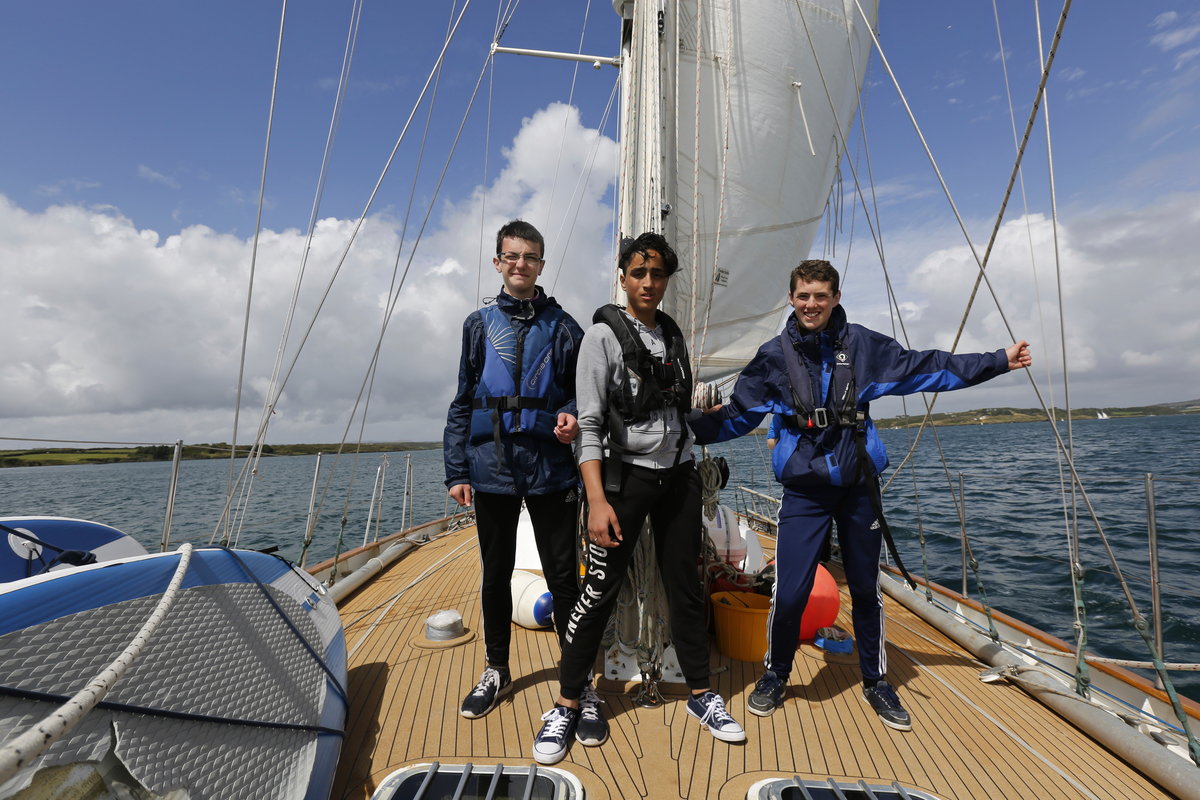 Ireland. A Syrian Asylum Seeker and two Irish teenagers on sail training vessel of the coast of West Cork