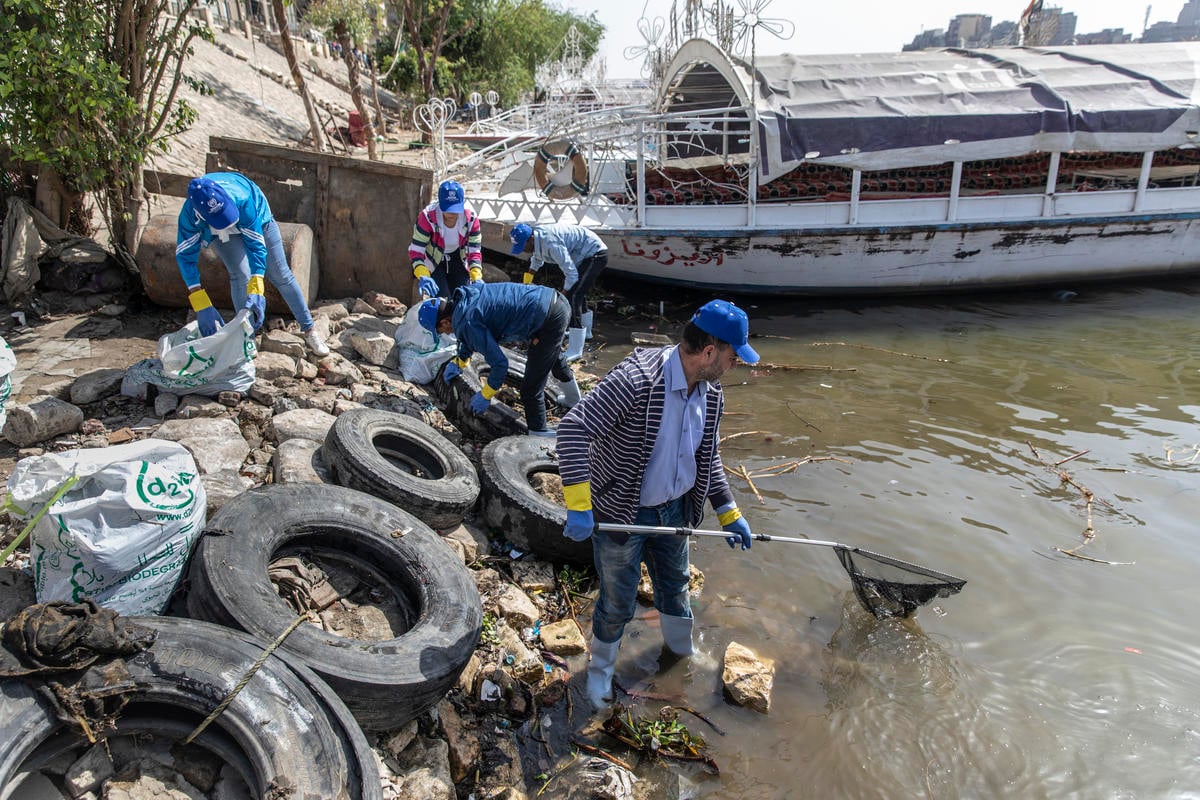 Refugees and locals clean the Nile together
