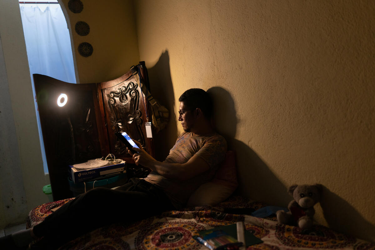 Nicaraguan asylum-seeker Óscar* reads from a tablet that he uses for professional development classes.
