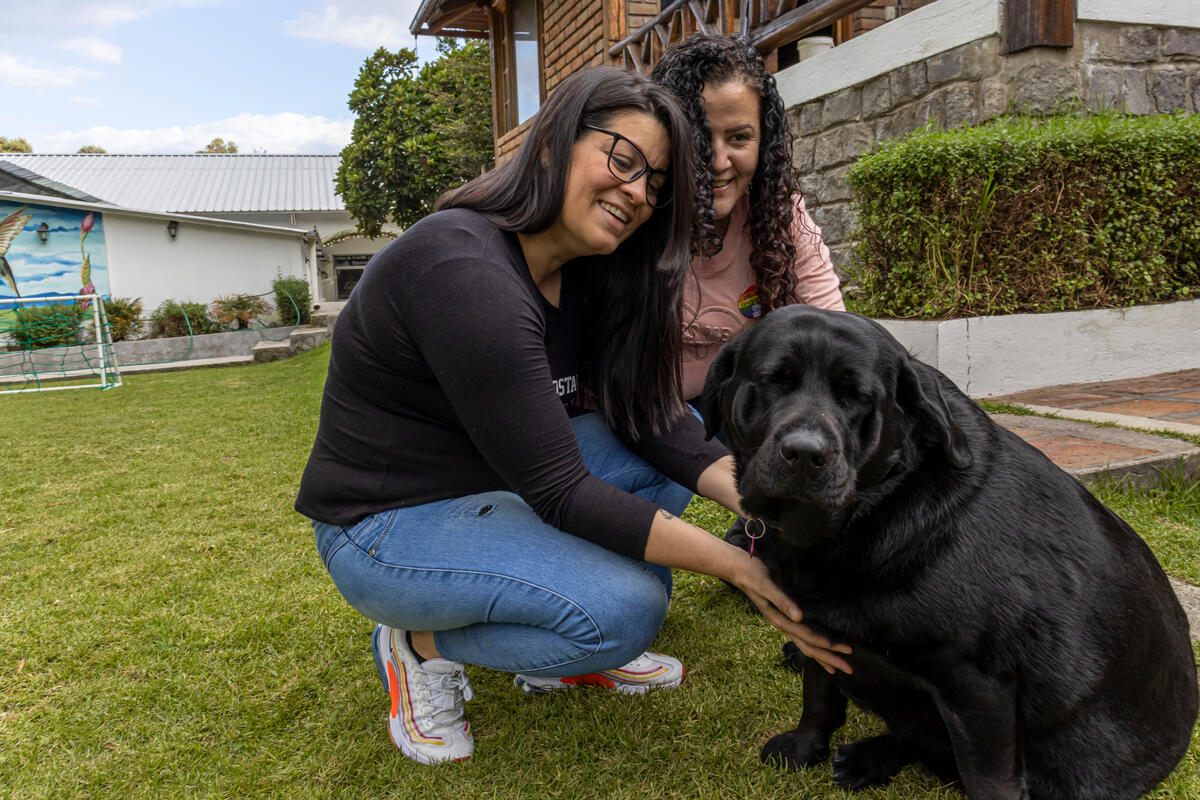 Zailet (left) and Yeraldine play with a dog at the Quito hotel where they both work.
