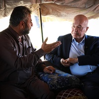 UN High Commissioner for Refugees Barham Salih talks with a displaced man in a shelter in Al-Hijra Camp.