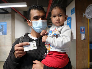 Raul and his toddler receive their documents in Colombia, where a regularization programme is facilitating the socio-economic inclusion of Venezuelans refugees and migrants.